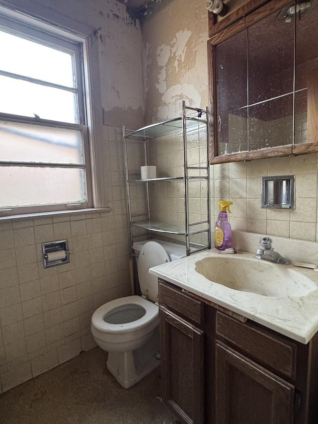 bathroom featuring vanity, toilet, and tile walls