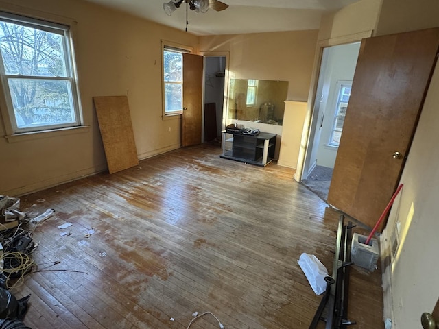 unfurnished living room featuring ceiling fan, a wealth of natural light, and light hardwood / wood-style floors