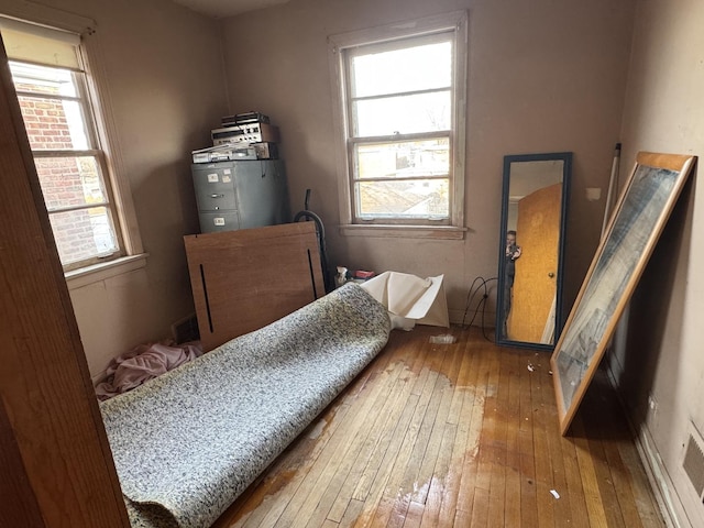 bedroom featuring hardwood / wood-style flooring and multiple windows