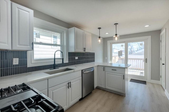 kitchen featuring backsplash, stainless steel dishwasher, sink, and white cabinets