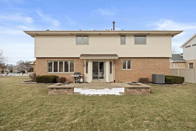 back of house with central AC unit, a fire pit, a patio area, and a yard