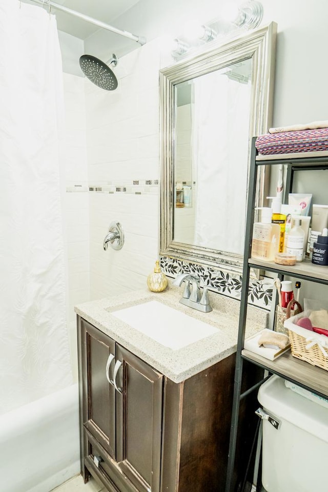 bathroom featuring toilet, vanity, and a tile shower