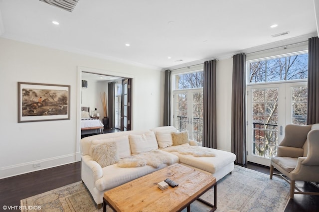 living room featuring crown molding, a wealth of natural light, and dark hardwood / wood-style floors