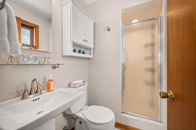 bathroom with sink, toilet, and a shower with door