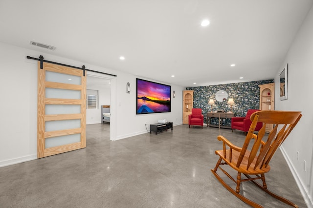 sitting room with a barn door and concrete flooring