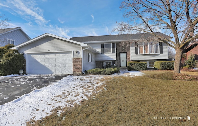 bi-level home featuring a garage and a lawn