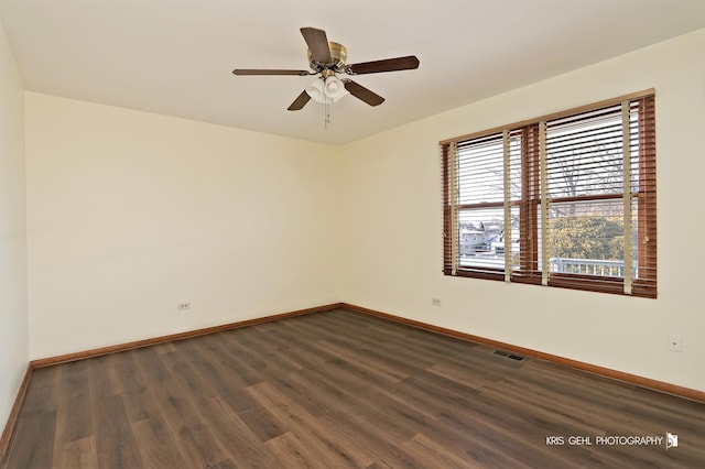 empty room with ceiling fan and dark hardwood / wood-style flooring