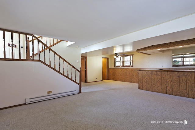 basement with a baseboard radiator, plenty of natural light, and light carpet