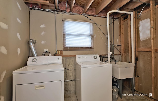 clothes washing area featuring washing machine and dryer and sink