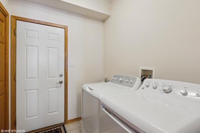 clothes washing area with light tile patterned flooring and washer and clothes dryer