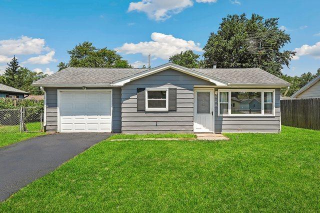 single story home featuring a garage and a front yard