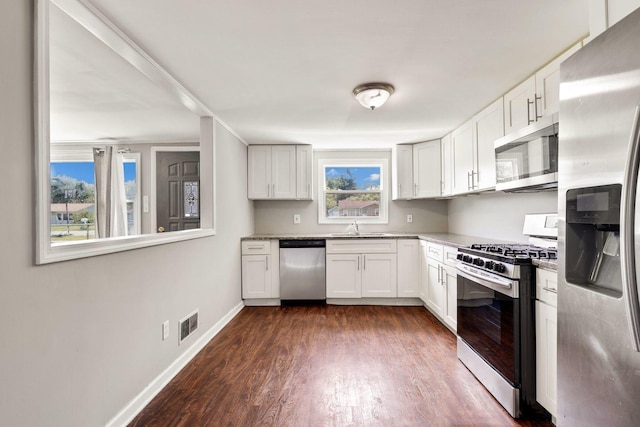 kitchen with white cabinetry, appliances with stainless steel finishes, sink, and dark hardwood / wood-style floors