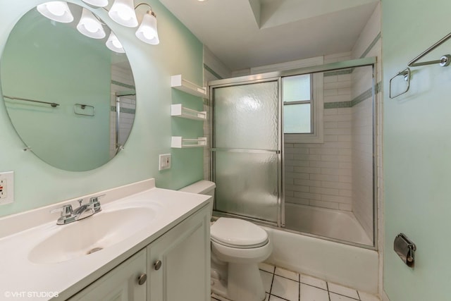 full bathroom featuring vanity, shower / bath combination with glass door, toilet, and tile patterned flooring