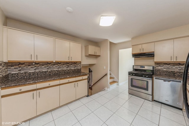 kitchen featuring cream cabinets, dark stone counters, and appliances with stainless steel finishes