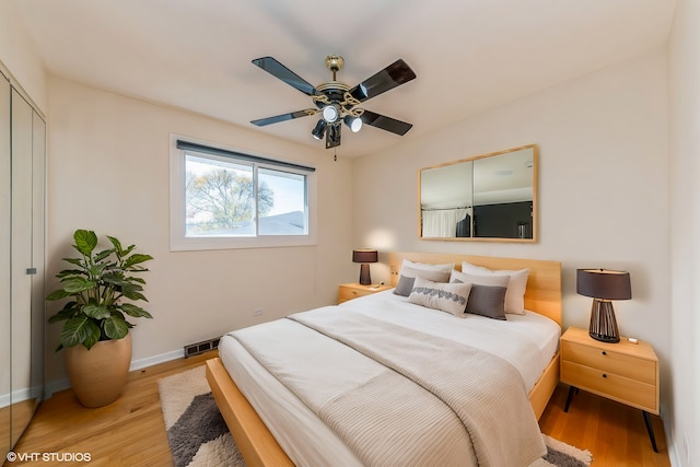 bedroom with light hardwood / wood-style floors, a closet, and ceiling fan