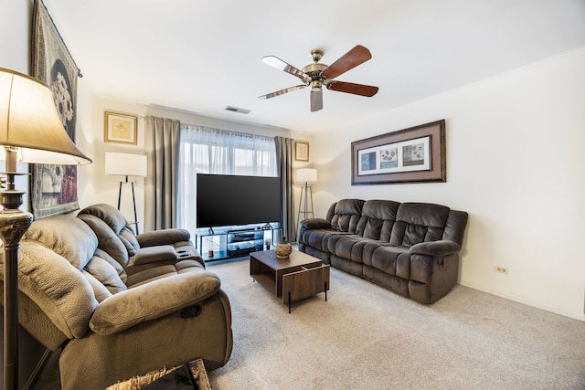 carpeted living room with ceiling fan and ornamental molding