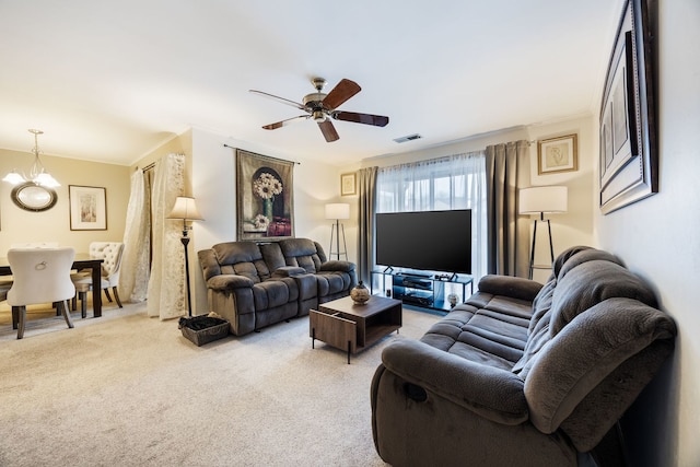 carpeted living room with ceiling fan with notable chandelier and crown molding