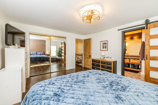 bedroom featuring a closet, dark hardwood / wood-style floors, and a barn door