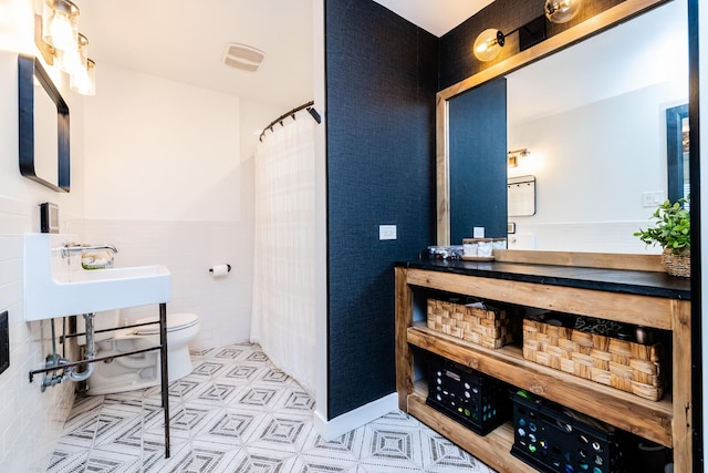 bathroom featuring tile walls and toilet