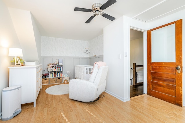 living area featuring wood-type flooring and ceiling fan