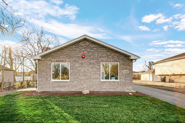 view of property exterior featuring central AC unit and a lawn