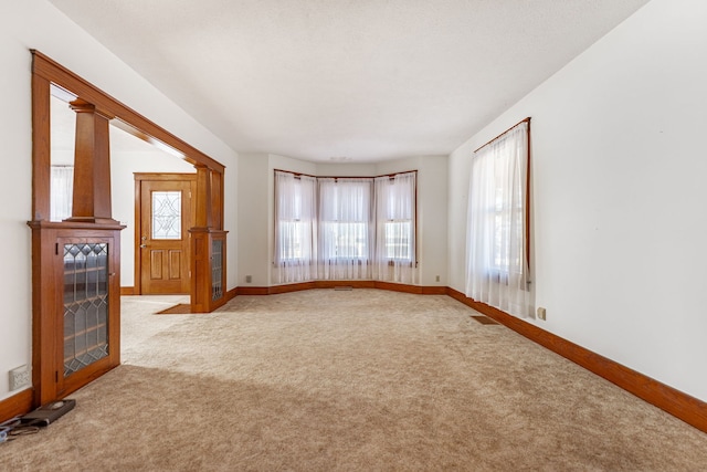 carpeted empty room with visible vents and baseboards