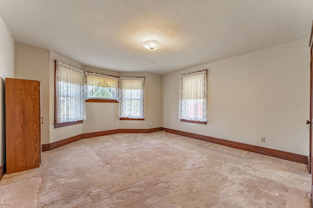 unfurnished room featuring carpet floors and baseboards