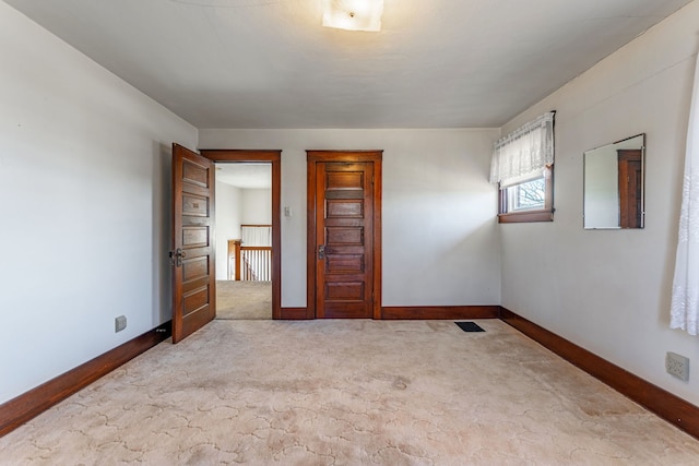 spare room with light carpet and baseboards