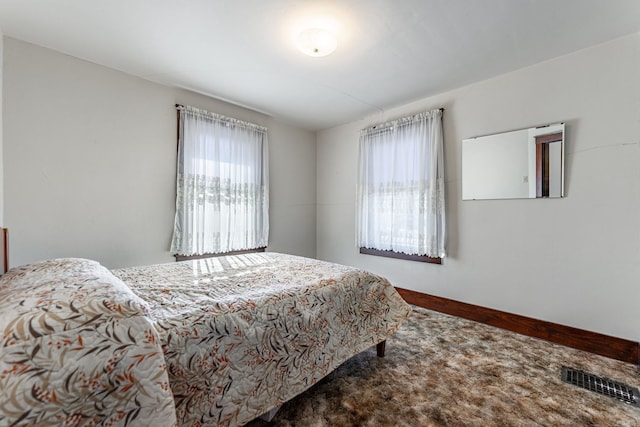 bedroom with visible vents, baseboards, and multiple windows