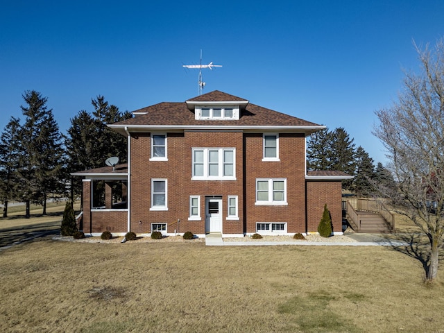 view of front facade with brick siding and a front yard