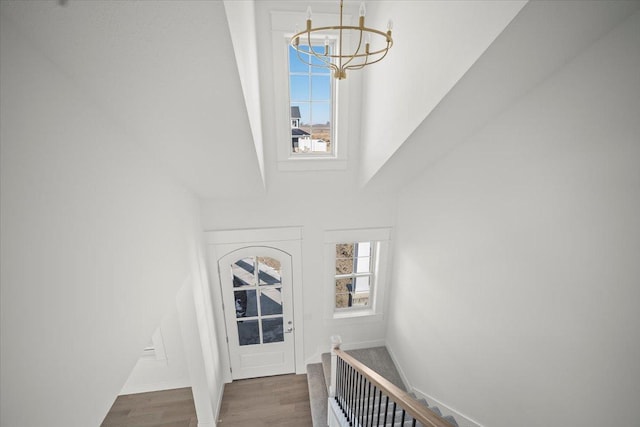 stairway featuring hardwood / wood-style flooring and a chandelier