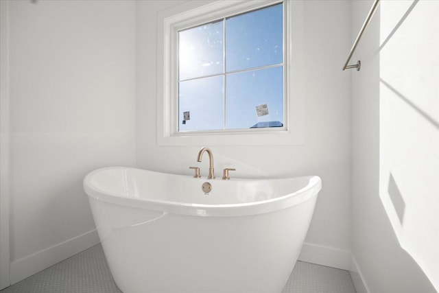 bathroom with tile patterned floors and a bathtub