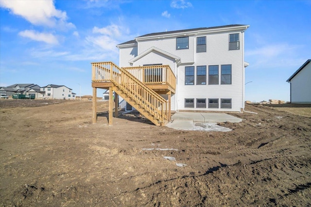 back of property with a wooden deck and a patio area