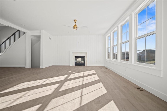 unfurnished living room with ceiling fan and light hardwood / wood-style flooring