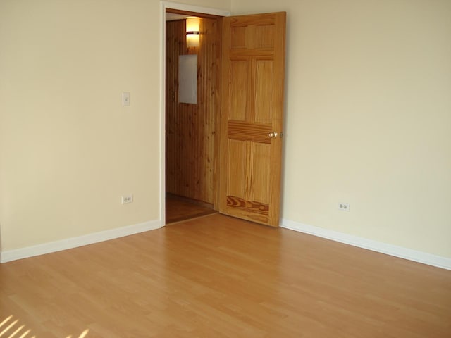 spare room featuring electric panel and hardwood / wood-style floors