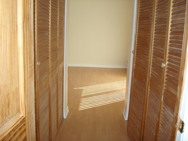 corridor with hardwood / wood-style flooring