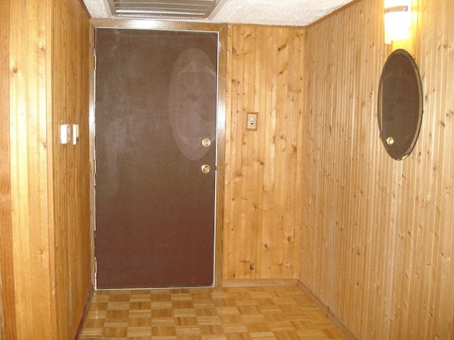 hall with light parquet flooring and wood walls