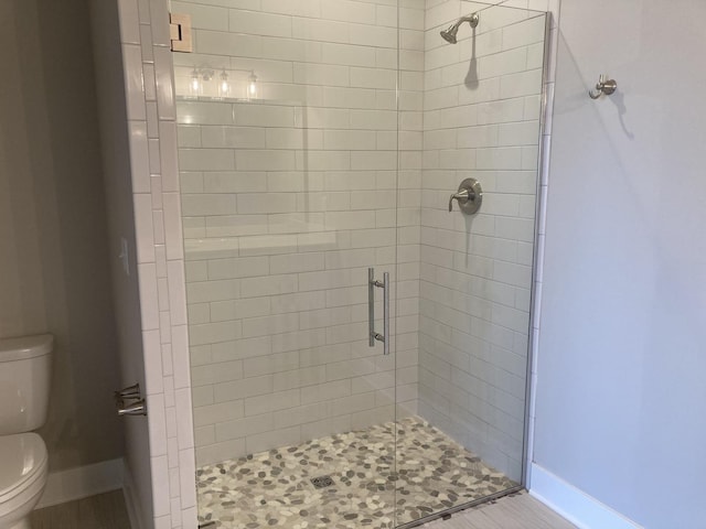 bathroom featuring toilet and an enclosed shower