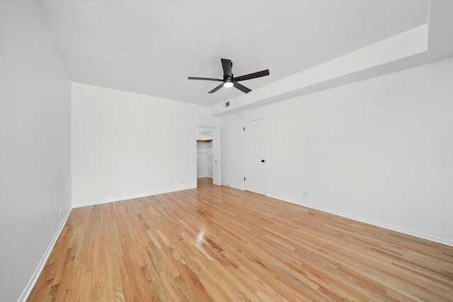 unfurnished room with ceiling fan, light hardwood / wood-style flooring, and a textured ceiling