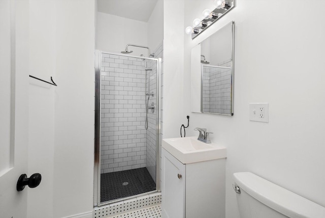 bathroom featuring a tile shower, vanity, and toilet