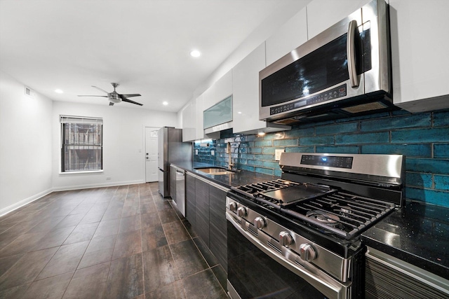 kitchen featuring sink, appliances with stainless steel finishes, white cabinets, ceiling fan, and backsplash