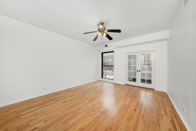 empty room featuring ceiling fan, light hardwood / wood-style floors, french doors, and a textured ceiling