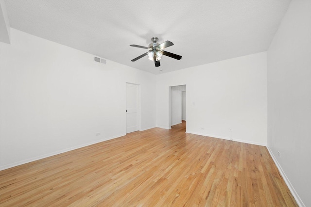 spare room with ceiling fan, a textured ceiling, and light wood-type flooring