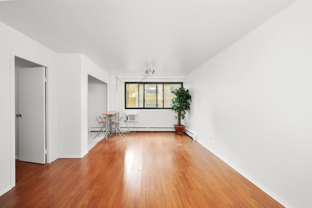 empty room featuring hardwood / wood-style flooring, a wall mounted AC, and a baseboard heating unit