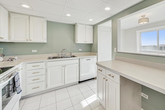 kitchen featuring sink, white appliances, light tile patterned floors, white cabinetry, and a drop ceiling