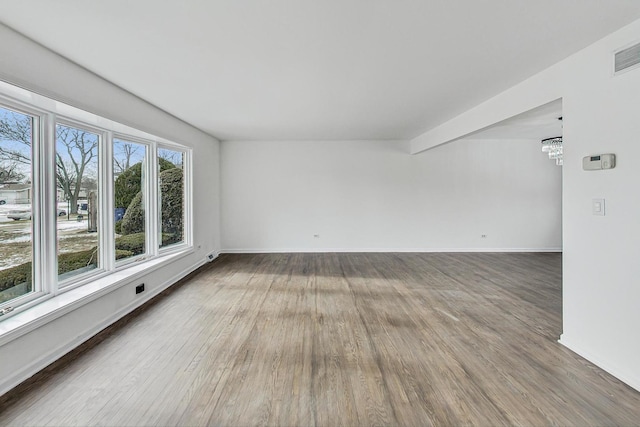 unfurnished room featuring a chandelier and hardwood / wood-style floors