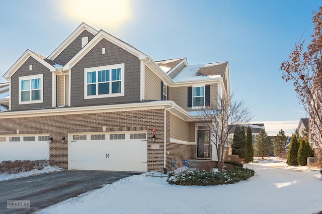 craftsman-style house featuring driveway, an attached garage, and brick siding