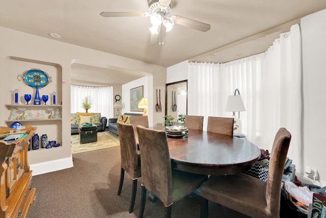 carpeted dining room featuring ceiling fan