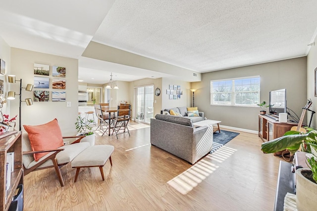 living room with light wood-type flooring and a textured ceiling