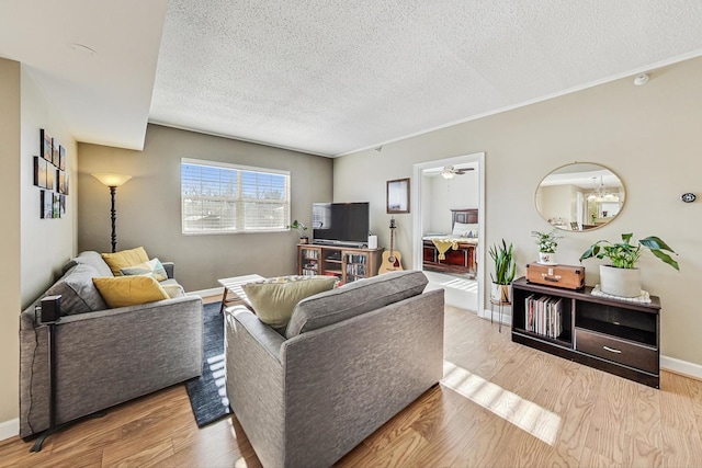 living room featuring light wood-type flooring, a textured ceiling, and ceiling fan